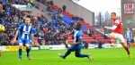 Arsenal's Lukas Podolski (right) has a shot on goal