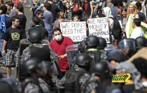Activists demonstrate in front of riot police outside the Mane Garrincha National Stadium in Brasilia